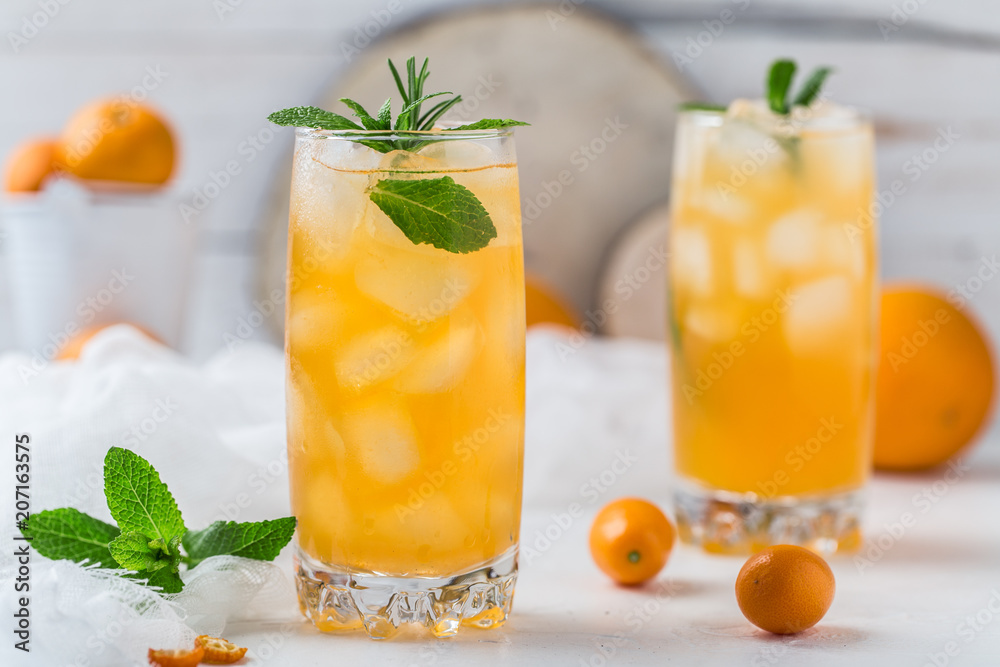 Fresh summer cocktail with orange juice and ice cubes. Glass of orange soda drink on white background