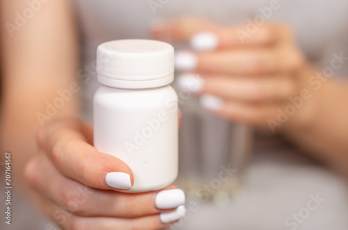 Woman sick in hands glass of water and jar of pills medecine sick pharmacy