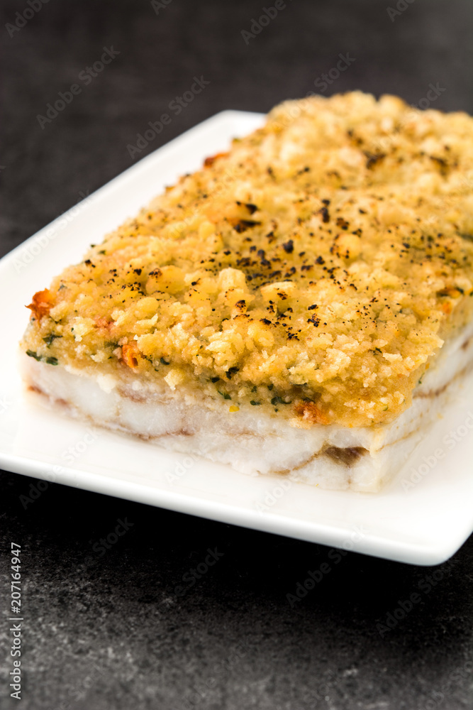 White fish casserole with cheese on black stone