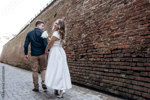 The lovely couple in love walking along narrow street
