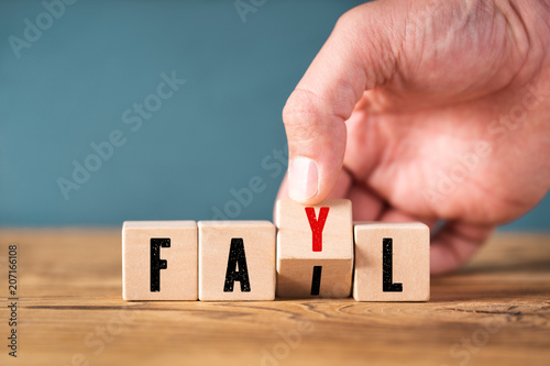 Hand corrects spelling of the word "fail"