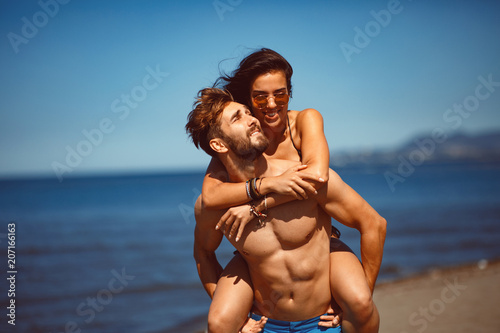 Young happy couple in a embrace on the beach