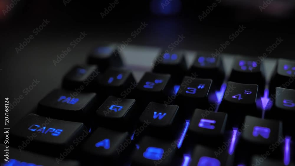 Glowing keyboard hackier style glittering at the night workplace with different light colors Glowing keyboard hackier style glittering at the night workplace with different light colors
