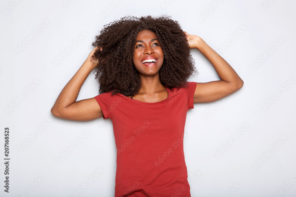 happy young african american woman smiling with hands in hair on white background happy young african american woman smiling with hands in hair on white background