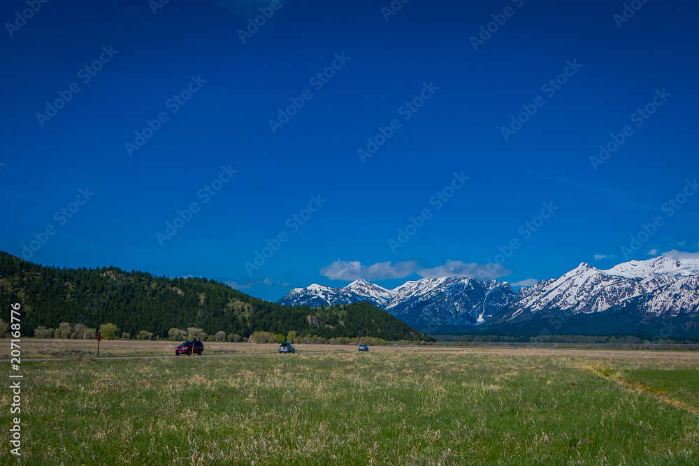 Beautiful landscape of the Grand Tetons range and peaks located inside the Grand Teton National Park, Wyoming, with house mountain covered with snow in the horizont