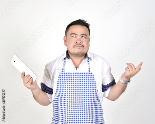 merchant Asian man in white and blue apron is feeling regret or boring
when get bad news from connection internet in tablet with white background photo