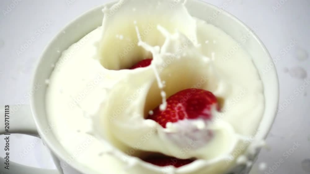 Berries of strawberry fall in milk. Slow motion. Berries of strawberry fall in milk. Slow motion.