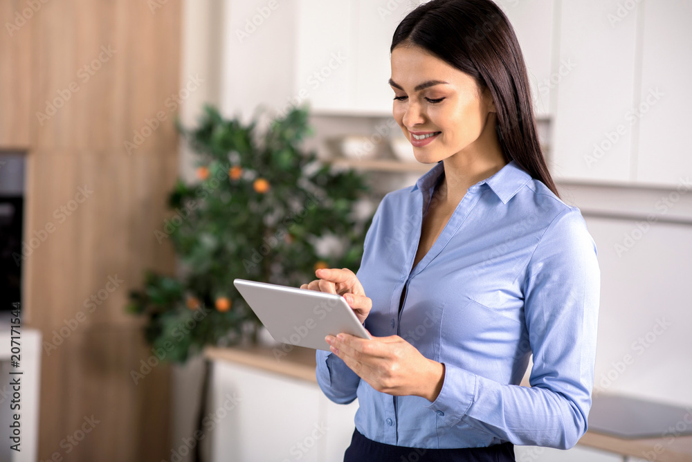 Joyful businesswoman using her tablet Joyful businesswoman using her tablet