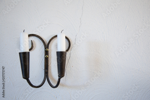 Black wall candles holder on grunge wall background © taaree