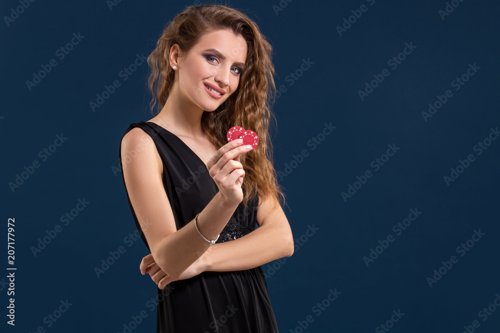 Portrait of the female gambler at the casino keeping poker chips in the hand Portrait of the female gambler at the casino keeping poker chips in the hand