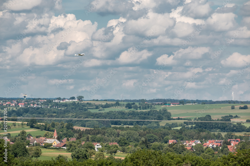Little plane approaching and the green german countryside