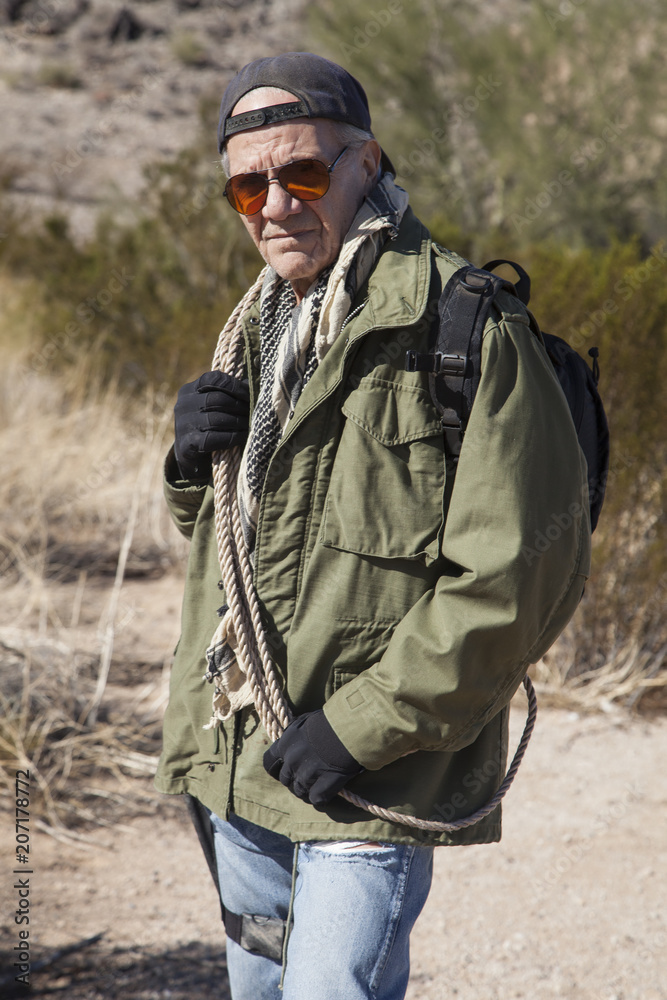 Senior man on a hike with survival equipment.
