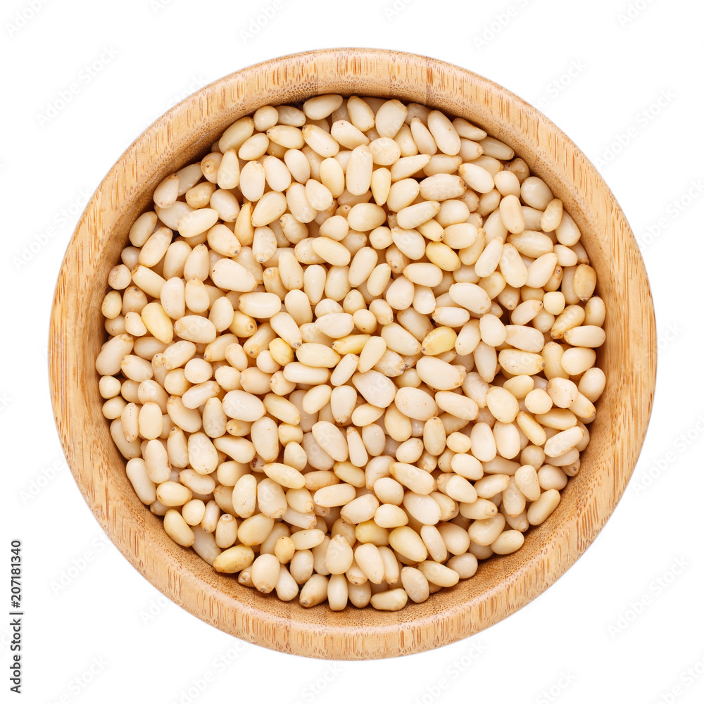 Pine nuts in wooden bowl isolated on white. Top view. Pine nuts in wooden bowl isolated on white. Top view.