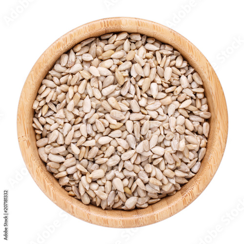 Sunflower seeds in wooden bowl isolated on white. Top view.