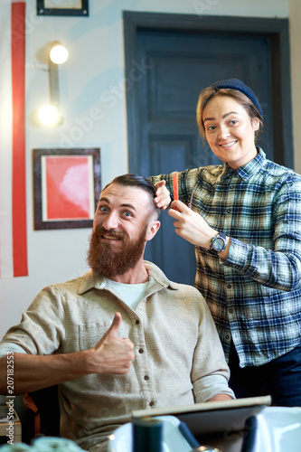 Photo of hipster man getting haircut by hairdresser