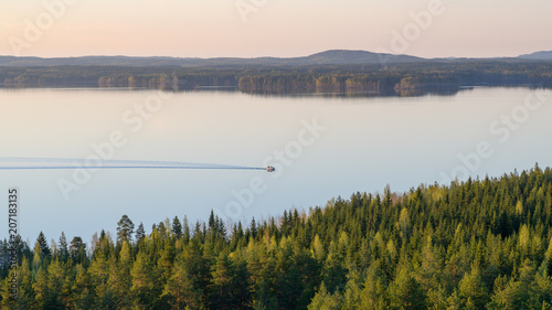 Lonely boater on a lake Lievestuoreenjärvi at sunset. Finland, Laukaa, view from Hyyppäänvuori.