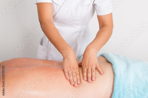 woman making man back massages in a beauty saloon