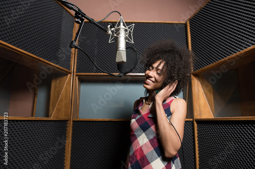 Young woman singing in studio photo