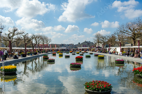 AMSTERDAM, The NETHERLANDS - APR 2, 2017 : The beautiful Museum Square with a pond and floating tulips. The Music Hall on the background