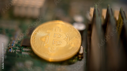 Bitcoin mining process - gold coin on computer circuit board with bitcoin processor and microchips. Electronic currency, internet finance rypto currency concept. Golden Bitcoin Cryptocurrency photo