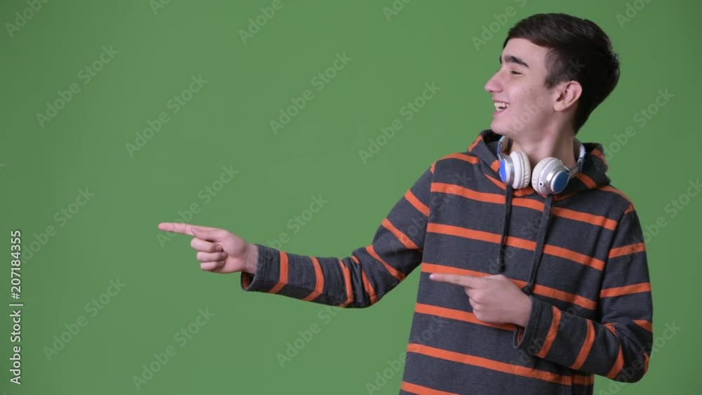 Young handsome Iranian teenage boy against green background Young handsome Iranian teenage boy against green background