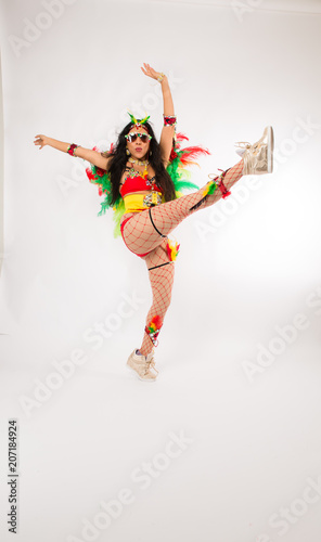 Very fit young hispanic woman in Carnaval costume and athletic shoes posing on clean white background © Jeremy Francis
