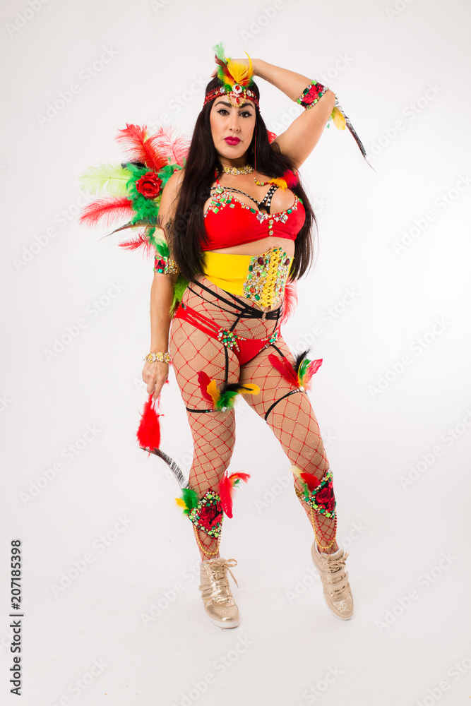 Dark haired hispanic woman in Carnaval costume and athletic shoes posing on clean white background Dark haired hispanic woman in Carnaval costume and athletic shoes posing on clean white background