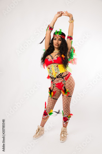 Fit young dark haired hispanic woman in Carnaval costume and athletic shoes posing on clean white background © Jeremy Francis