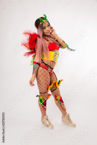 Fit young asian woman in Carnaval costume and athletic shoes posing on clean white background
