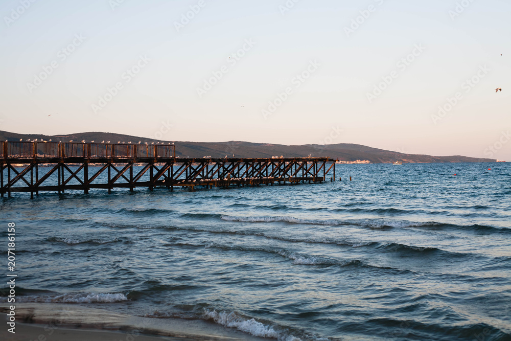 Wooden pier on the sea at sunset.