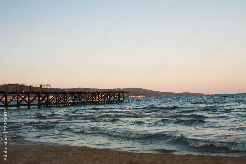 Obraz premium Wooden pier on the sea at sunset.