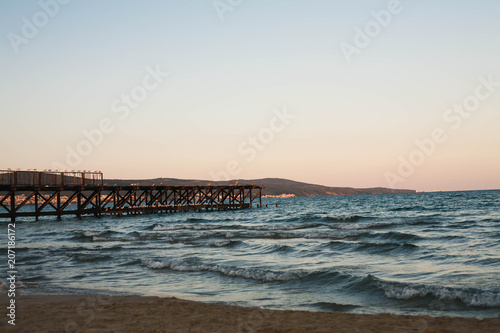Wooden pier on the sea at sunset.