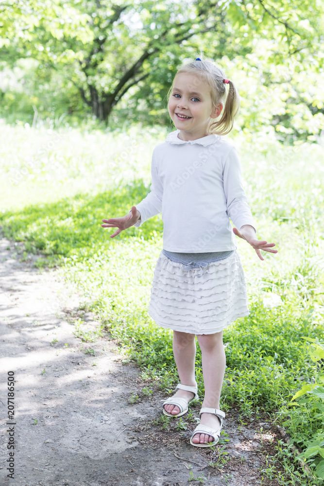 Portrait of a little beautiful girl in white clothes in the park Portrait of a little beautiful girl in white clothes in the park
