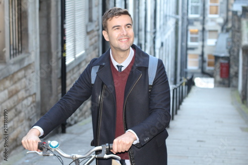 Stylish active man holding a bicycle outdoors