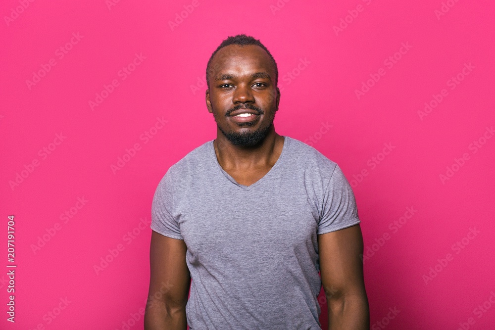 Portrait of an African man standing on a pink background Portrait of an African man standing on a pink background