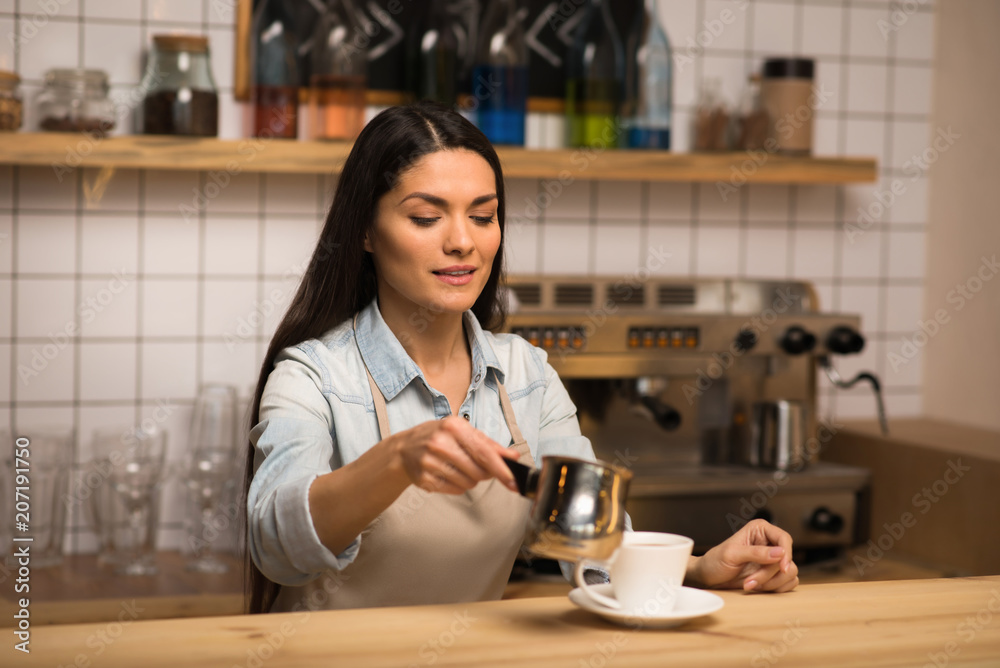 barista pouring milk into coffee barista pouring milk into coffee