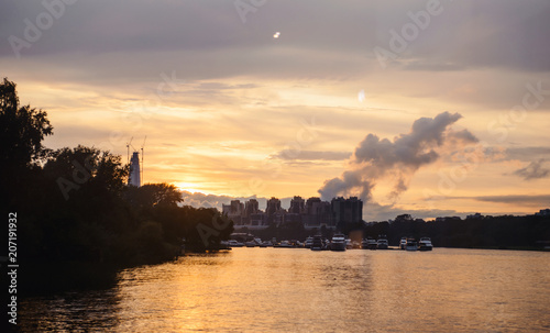 Evening orange sunset over Gulg of Finland, Russia nature landscape photography. Autumn sunset, outdoor nature of Russia. Fantastic sunset over lake near green meadow. Autumn nature sunset