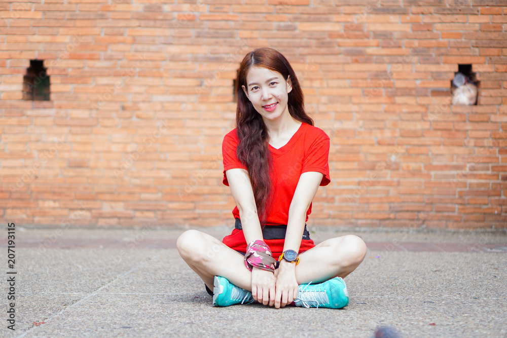 Cute girl with white skin, wearing red shirt, sitting with red brick ancient background. Cute girl with white skin, wearing red shirt, sitting with red brick ancient background.