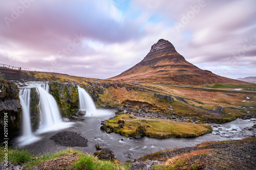 Summer sunset over the famous Kirkjufellsfoss Waterfall with Kirkjufell mountain in the background in Iceland. Long exposure HDR. May 2018.