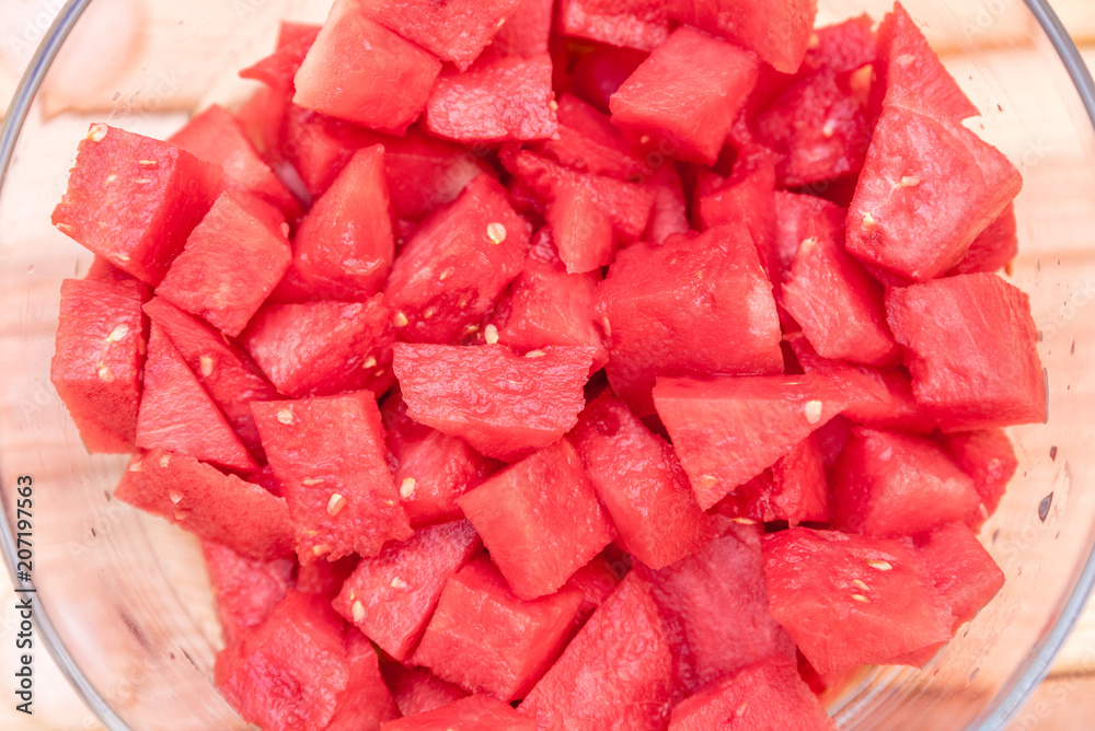 glass bowl with pieces of watermelon on wooden background glass bowl with pieces of watermelon on wooden background