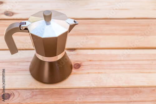 Italian brown coffee maker on wooden background photo