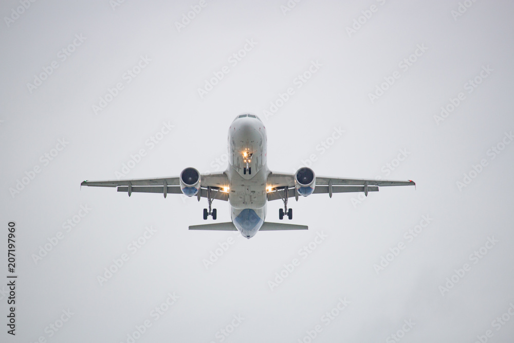 White airplane flying against a white sky
