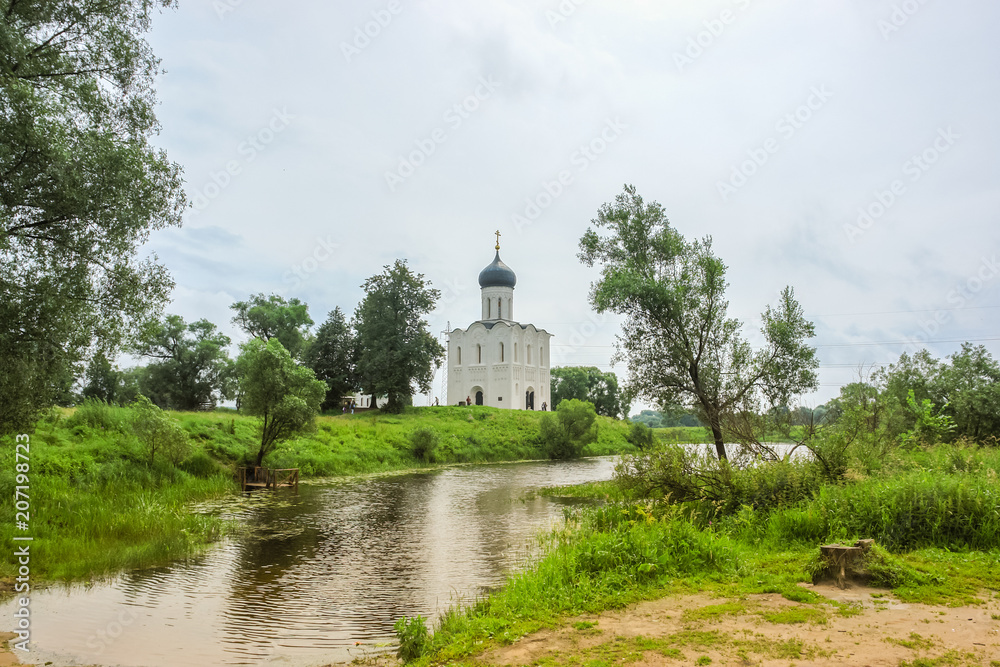 Sunny spring landscape. White church on the river, in the countryside