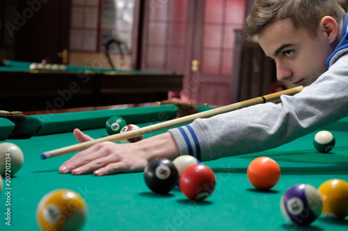 Young man plays billiards. hobbies