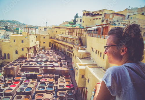 Billede på lærred Tourist visiting Fez in the middle of souk, traditional leather tannery from the