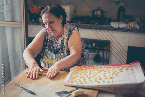 Wallpaper Mural italian woman make homemade pasta gnocchi on wood board. Typical senior woman from south of Italy makes pasta from dough  Torontodigital.ca