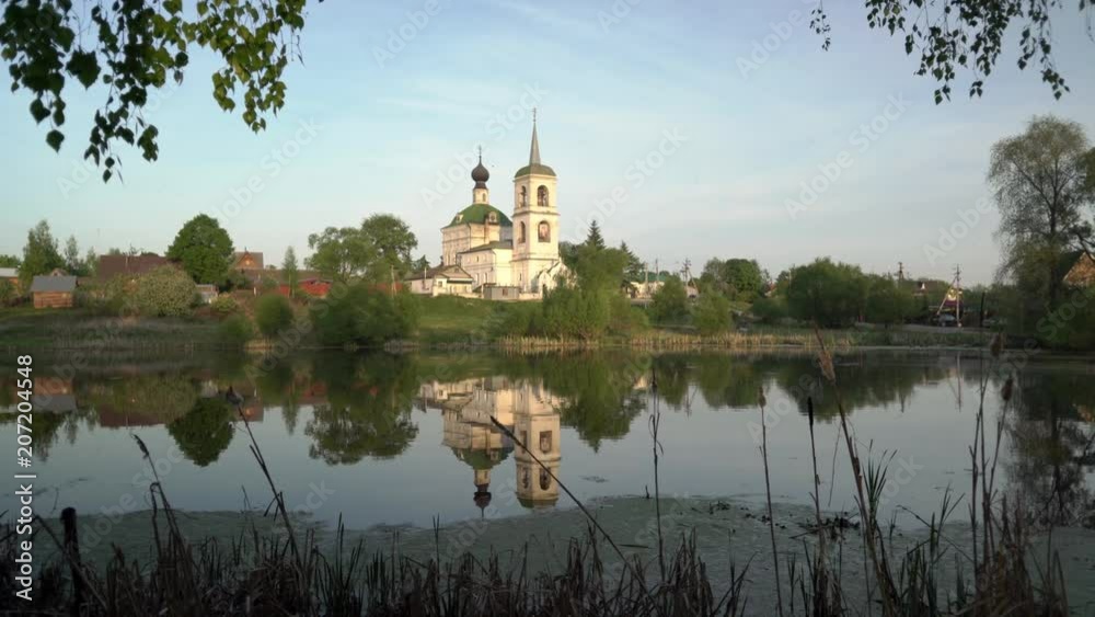 The old village Church is reflected in the surface of the pond. Russia. Domodedovo. The old village Church is reflected in the surface of the pond. Russia. Domodedovo.