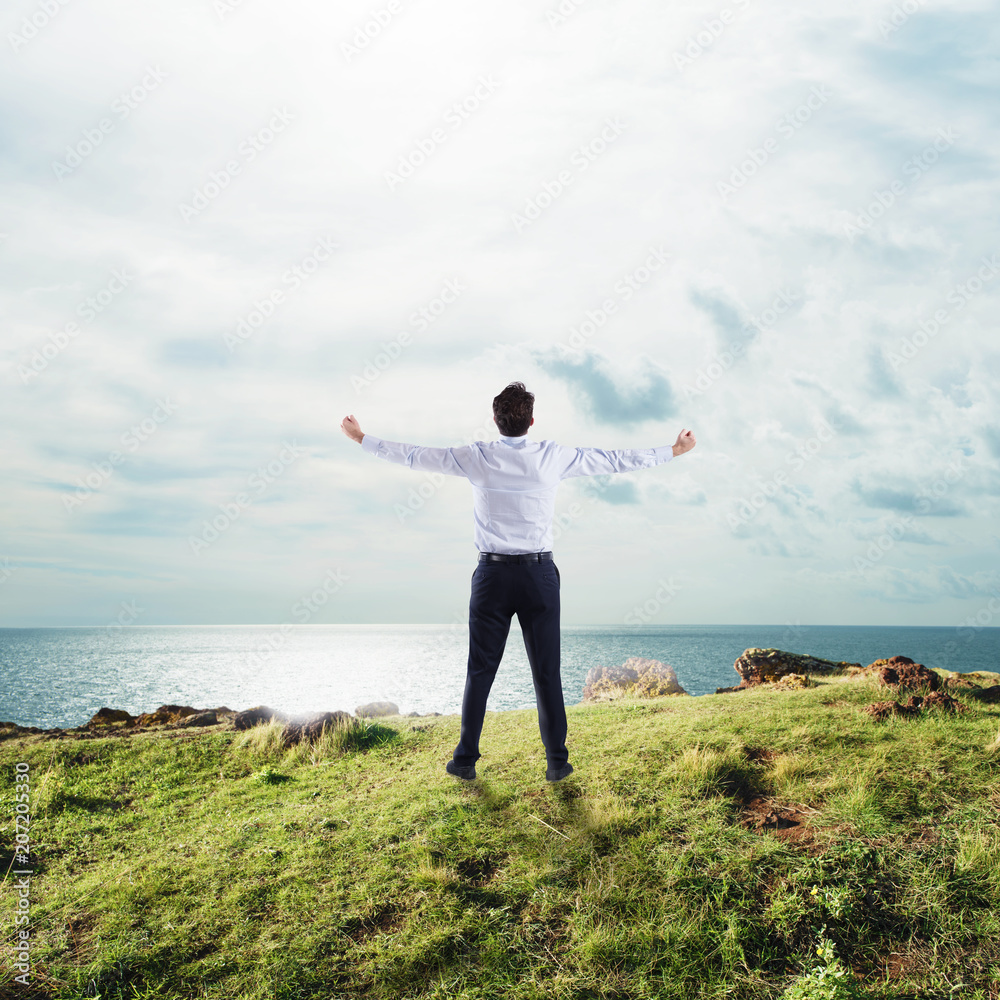 Businessman with open arms to the sky. concept of success and freedom Businessman with open arms to the sky. concept of success and freedom