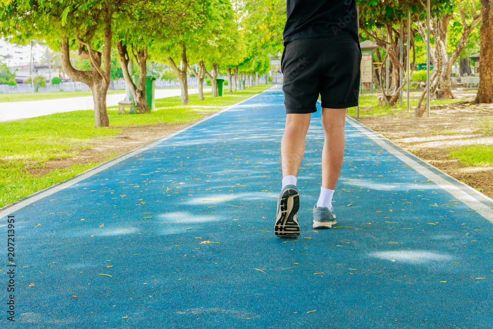 running feet male in runner jogging exercise with old shoes for health lose weight concept on track rubber cover blue public park. copy space add text running feet male in runner jogging exercise with old shoes for health lose weight concept on track rubber cover blue public park. copy space add text