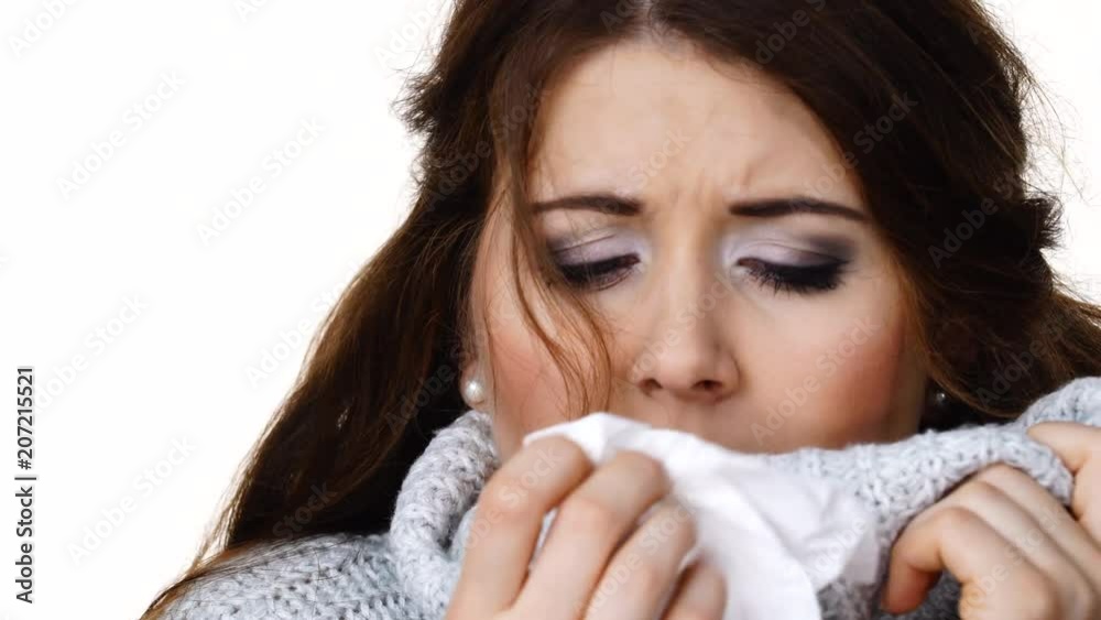 Sick freezing woman sneezing in tissue. Girl wearing warm sweater being cold and trembling. Flu or other virus. Health care. Sick freezing woman sneezing in tissue. Girl wearing warm sweater being cold and trembling. Flu or other virus. Health care.